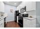 The kitchen features white cabinets and a black appliance suite including a range, microwave, and refrigerator at 12663 Windyedge Rd, Huntersville, NC 28078