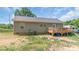 View of the backyard of this cozy home with a wooden deck and vinyl siding at 1316 Wiscassett St, Albemarle, NC 28001