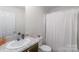 Bright bathroom featuring single sink vanity and shower with white curtain at 1316 Wiscassett St, Albemarle, NC 28001