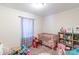 Bright bedroom with light-colored walls, pink crib, and gray shelving unit for toys and books at 1316 Wiscassett St, Albemarle, NC 28001