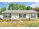 Charming single-story home features neutral siding, black shutters, well-maintained yard, and inviting front porch at 1316 Wiscassett St, Albemarle, NC 28001