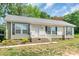 Charming single-story home features neutral siding, black shutters, well-maintained yard, and inviting front porch at 1316 Wiscassett St, Albemarle, NC 28001