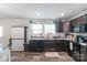 Open kitchen with dark cabinets, stainless steel appliances, laminate countertop, new laminate flooring, and open eating area at 1316 Wiscassett St, Albemarle, NC 28001