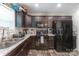 Modern kitchen with dark cabinets, stainless steel appliances, laminate countertop, and new laminate flooring at 1316 Wiscassett St, Albemarle, NC 28001