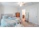 Bright bedroom features a comfortable bed, wooden dresser, and view into the ensuite bathroom at 1316 Wiscassett St, Albemarle, NC 28001