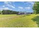 Large grassy backyard with trees, playset, above ground pool, and charming single-story home at 135 Waycross Dr, Rockwell, NC 28110