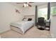 Bedroom featuring a ceiling fan, gray bed, window, desk, and carpeting at 1365 Eagle Claw Dr, Kannapolis, NC 28083