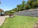 This backyard features a retaining wall, an umbrella and a beautiful, well-maintained lawn at 14128 Morningate St, Huntersville, NC 28078