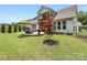 This backyard offers a patio, a well-manicured lawn, a black fence and some beautiful trees at 14128 Morningate St, Huntersville, NC 28078