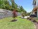 This backyard features a retaining wall, well-maintained lawn, patio, and nice trees at 14128 Morningate St, Huntersville, NC 28078