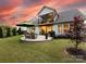 Spacious backyard featuring a stone patio with outdoor seating, lush lawn, and manicured landscaping at 14128 Morningate St, Huntersville, NC 28078