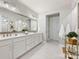 Elegant bathroom with double vanity sinks, white marble floors, and modern lighting at 14128 Morningate St, Huntersville, NC 28078