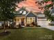 Charming home featuring a landscaped front yard, inviting porch, and stylish architectural details at 14128 Morningate St, Huntersville, NC 28078