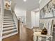 Bright hallway with hardwood floors, staircase, and comfortable seating next to an elegant wall art at 14128 Morningate St, Huntersville, NC 28078