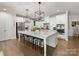 Bright kitchen features a large island with granite countertop and modern pendant lighting at 14128 Morningate St, Huntersville, NC 28078