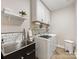 Well-organized laundry room featuring modern washer and dryer, storage cabinets, and a utility sink at 14128 Morningate St, Huntersville, NC 28078
