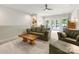 Bright living room featuring a leather sofa, modern ceiling fan, and carpeted floors at 14128 Morningate St, Huntersville, NC 28078