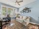 Bright office space with a cozy seating area, ceiling fan, and natural light at 14128 Morningate St, Huntersville, NC 28078
