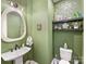 Charming powder room with green walls, pedestal sink, and decorative shelves at 14128 Morningate St, Huntersville, NC 28078
