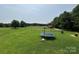 Expansive backyard with green grass, a trampoline, and a wooded area at 1545 Lewis Farm Rd, Kings Mountain, NC 28086