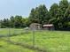 A view of two outdoor sheds with a chain link fence at 1545 Lewis Farm Rd, Kings Mountain, NC 28086
