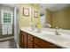 Bathroom featuring a double sink vanity, a large mirror, wood cabinets, and decor at 1621 California Rd, York, SC 29745