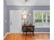 A charming entryway featuring hardwood floors, a decorative table with a lamp, and natural light from the window at 1621 California Rd, York, SC 29745