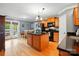 Well-lit kitchen featuring a center island with a black countertop, stainless steel appliances, and wood cabinets at 1621 California Rd, York, SC 29745
