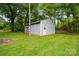 Exterior view of shed featuring a roll up door, grass, and a main front door entrance at 1621 California Rd, York, SC 29745