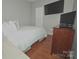 Well-lit bedroom with a mounted TV, hardwood floors, and a dresser for storage, maximizing space at 19182 Mallard Dr, Fort Mill, SC 29707