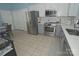 Modern kitchen featuring gray lower cabinets, stainless appliances, and tile backsplash with adjacent dining area at 19182 Mallard Dr, Fort Mill, SC 29707