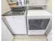 Modern laundry room with new Whirlpool washer and dryer, with shelving above, and tile floor at 19182 Mallard Dr, Fort Mill, SC 29707