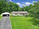 Lovely single-story home with a detached garage and a spacious front lawn, surrounded by mature trees at 2084 Old Evans Cir, Lancaster, SC 29720