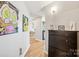 Inviting hallway with hardwood floors, unique art, and storage leading to a well-lit dining area at 210 N Church St # 2807, Charlotte, NC 28202