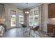 Bright dining area with glass table, modern chandelier, and views of the backyard through large windows at 215 Pintail Dr, Monroe, NC 28110