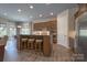A kitchen with an island, granite countertops, stools, wooden cabinets and stainless appliances at 215 Pintail Dr, Monroe, NC 28110