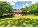Expansive backyard featuring a brick home, patio with outdoor seating, and lush greenery at 2209 Cardinal Loop, Stanley, NC 28164