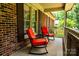 Close up of outdoor seating on a covered front porch that has access to the front door at 2209 Cardinal Loop, Stanley, NC 28164