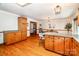 A kitchen featuring a breakfast bar, oak cabinets, and hardwood floors leading to dining area at 2209 Cardinal Loop, Stanley, NC 28164