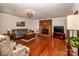 Spacious living room featuring hardwood floors, a brick fireplace, and ample seating at 2209 Cardinal Loop, Stanley, NC 28164