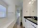 Bathroom with bathtub, modern vanity with black countertop, wood look flooring and a large mirror at 231 Brook Se Ave, Concord, NC 28025