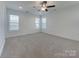 Bright bedroom featuring plush carpeting, a ceiling fan, and three windows, offering lots of natural light at 231 Brook Se Ave, Concord, NC 28025