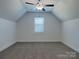 Attic bedroom featuring neutral carpet, a ceiling fan, and a window at 231 Brook Se Ave, Concord, NC 28025