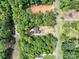 Aerial view of a house situated with a forest, next to water, gravel driveway, and a small yard at 248 Pioneer Dr, Mount Gilead, NC 27306