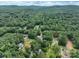 Expansive aerial view of a neighborhood nestled within a lush green forest with scattered houses at 248 Pioneer Dr, Mount Gilead, NC 27306