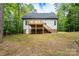 Backyard view featuring the home, a deck, and lush surrounding trees at 248 Pioneer Dr, Mount Gilead, NC 27306