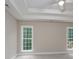 Spacious bedroom featuring tray ceiling, carpet, and large windows at 248 Pioneer Dr, Mount Gilead, NC 27306