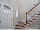 Inviting entryway featuring a staircase with wood railings and a freshly painted front door with glass inserts at 248 Pioneer Dr, Mount Gilead, NC 27306