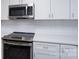 Close-up of a stainless steel oven, cooktop and microwave with a white subway tile backsplash at 248 Pioneer Dr, Mount Gilead, NC 27306