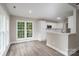 A bright kitchen with white cabinets, stainless steel appliances, and a breakfast bar overlooking the living area at 248 Pioneer Dr, Mount Gilead, NC 27306